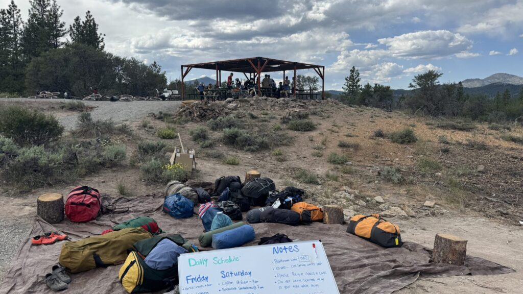 Shuttle bags laid out at High Camp with the shaded deck and mountains in the background