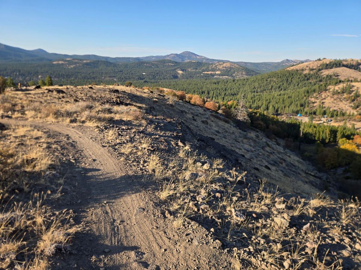 View from the Beckwourth Peak Trail looking down at Beckwourth Peak High Camp, with fall color and forested mountains beyond