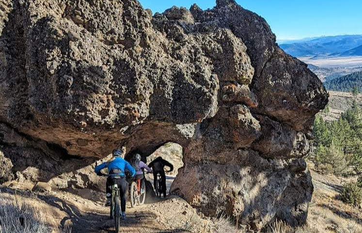 Mountain biker riding the arch feature on the Beckwourth Peak Trail, Lost Sierra