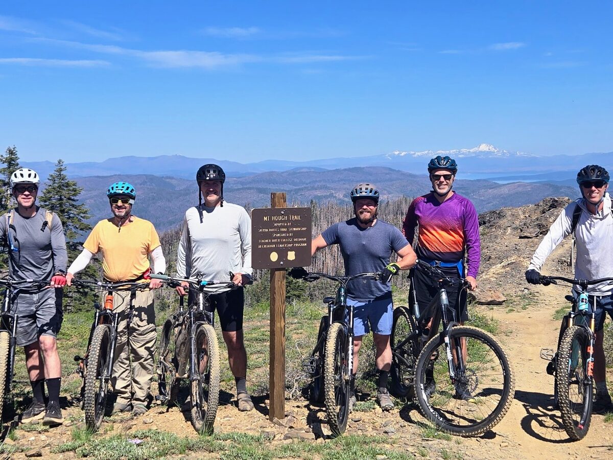 Group of mountain bikers at the Mt. Hough trail sign in the Lost Sierra